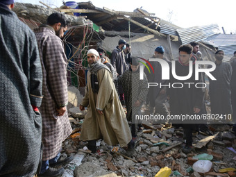 Kashmiri people assess the damaged residential house in Kanigam Village of Shopian district, South of Srinagar, Indian Administered Kashmir...