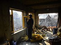 A Kashmiri man clicks picture inside a damaged residential house in Kanigam Village of Shopian district, South of Srinagar, Indian Administe...