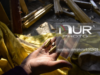 A Kashmiri man shows the bullet cartridges inside a damaged residential house in Kanigam Village of Shopian district, South of Srinagar, Ind...
