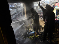 Kashmiri people douse the fire inside a damaged residential house in Kanigam Village of Shopian district, South of Srinagar, Indian Administ...