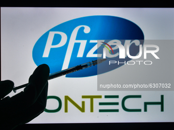 An illustrative image of a medical syringe in front of Pfizer-BionTech logo displayed on a screen.
On Monday, December 28, 2020, in Dublin,...