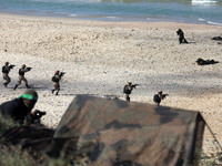 Armed fighters take part in a military drill by Hamas and other Palestinian armed factions on a beach in Gaza City on December 29, 2020.
 (