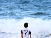 A boy wearing a Cristiano Ronaldo Juventuss shirt takes part in a traditional sea bath to welcome the new year at Carcavelos beach on the ou...