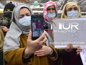 Relative of killed alledged militant shows the picture of one of the boys killed in encounter Athar Aijaz during protest in Srinagar, Indian...