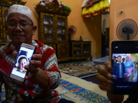 Riski Simamora and Abdul Khaliq showing a photo of Indah Halima Putri and her son Arka at their residence in Sungai Pinang, Ogan Ilir Regenc...