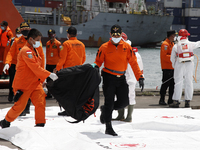 Indonesian National Search And Rescue Agency personnels carry body bags containing body parts of the victims of Sriwijaya Air Boeing 737-500...