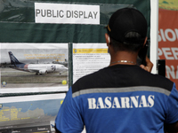 Personnels of Indonesian Search And Rescue Agency pay attention to the information board regarding the Sriwijaya Air Boeing 737-500 accident...