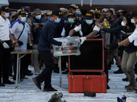 Indonesian National Safety Transportation Commite personnels put the Flight Data Recorder (FDR) of crashed Sriwijaya Air Fliight SJ182 to th...