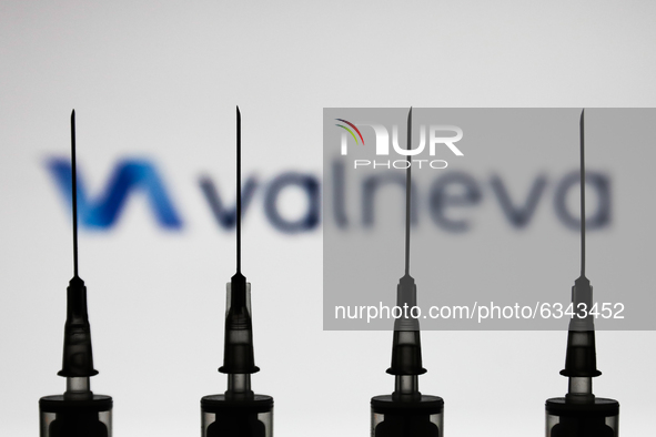 Medical syringes are seen with Valneva company logo displayed on a screen in the background in this illustration photo taken in Poland on Ja...