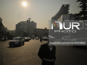 An Iranian traffic police officer wearing a protective face mask stands on a corner of a square in northern Tehran during a polluted air, fo...