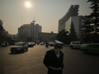 An Iranian traffic police officer wearing a protective face mask stands on a corner of a square in northern Tehran during a polluted air, fo...