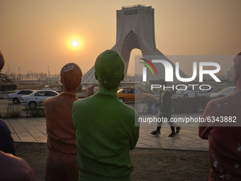 Two Iranian men wearing protective face masks walk along the Azadi (Freedom) square in western Tehran during a polluted air, following the C...