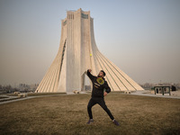 An Iranian man plays badminton in the Azadi (Freedom) square in western Tehran during a polluted air, following the COVID-19 outbreak in Ira...