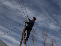 A Power Development Department (Electricity) Lineman repairs a Power line in Hajibal on the outskirts of District Baramulla Jammu and Kashmi...
