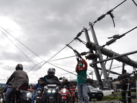 An electrician is repairing a flow pole that collapsed into the middle of a road in Mamuju Regency, West Sulawesi, on Saturday 16 January 20...