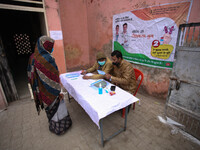 Police officials check identity card of a health worker before get vaccinated,  at a hospital  in the outskirts of Allahabad on January 16,2...