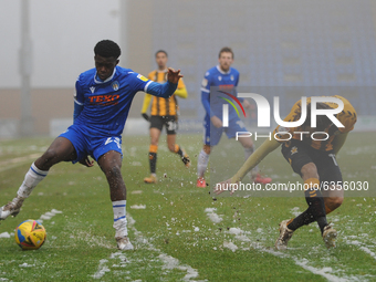 Cambridges Harrison Dunk and Colchesters Kwame Poku in the snow during the Sky Bet League 2 match between Colchester United and Cambridge Un...