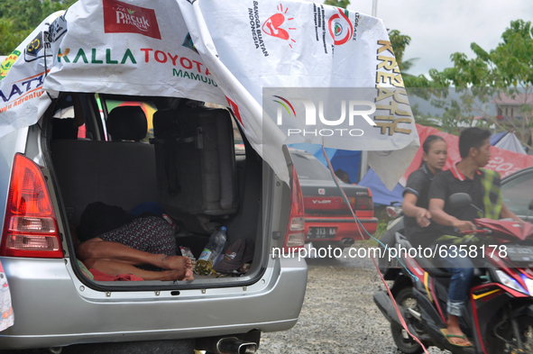 Residents of earthquake victims passed by motorbikes at the Manakarra Stadium evacuation post, Mamuju Regency, West Sulawesi Province, Indon...
