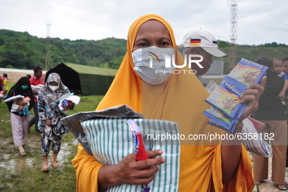 Earthquake survivors display food aid and blankets from aid at the Manakarra Stadium refugee post, Mamuju Regency, West Sulawesi Province, I...