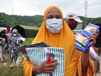 Earthquake survivors display food aid and blankets from aid at the Manakarra Stadium refugee post, Mamuju Regency, West Sulawesi Province, I...