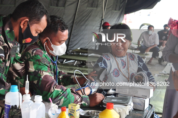 An earthquake survivor is being checked for health by Indonesian National Army personnel at the Manakarra Stadium refugee post, Mamuju Regen...