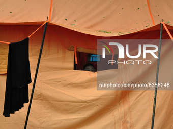 A child who is a refugee peeks out of the window of the emergency tent at the Manakarra Stadium refugee post, Mamuju Regency, West Sulawesi...