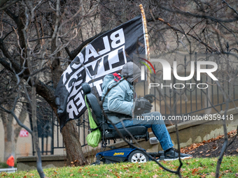A man in a wheelchair carrying a Black Lives Matter flag is seen during an armed protest at the Ohio Statehouse ahead of the inauguration of...