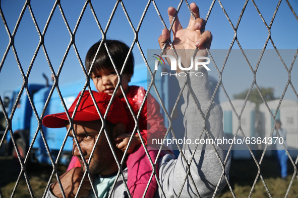 A man with a child inside refugee transfer camp in Opatovac near border crossing point between Serbia and Croatia. Opatovac, Croatia. Septem...