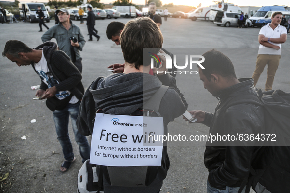 A volunteer offers free wifi to migrants who wait to enter the transfer camp in Opatovac near border crossing point between Serbia and Croat...