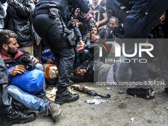 A migrant collapses while waiting to enter to the transfer camp in Opatovac near border crossing point between Serbia and Croatia. Opatovac,...
