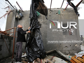 A Palestinian man inspects a damaged house near the border fence with Israel, in central Gaza Strip January 20, 2021. (