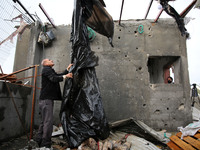 A Palestinian man inspects a damaged house near the border fence with Israel, in central Gaza Strip January 20, 2021. (