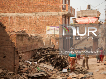 Bhaktapur locals walk past the destruction left from Nepal's two major earthquakes, last month. Most families in this area have completely l...