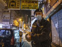 A Police officer pulls a police tape down a road to corders off an area in Jordan District on January 23, 2021 in Hong Kong, China. The Hong...