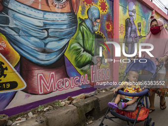 A woman passing by the mural in Tangerang, Banten, Indonesia, 26 January 2021. Indonesia reach out to 1 million of Covid19 positive case wit...