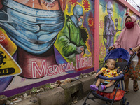 A woman passing by the mural in Tangerang, Banten, Indonesia, 26 January 2021. Indonesia reach out to 1 million of Covid19 positive case wit...