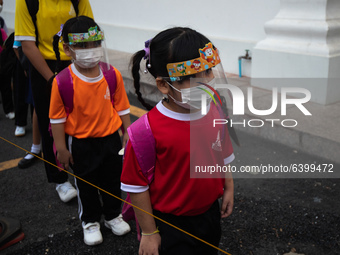 Elementary school students wearing a face shield as a preventive measure arriving at Sri Iam Anusorn School on February 1, 2021 in Bangkok,...