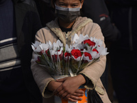 A Girl selling Red rose flower on the occasion of Valentine’s Day in Patan Durbar Square, Lalitpur, Nepal on Sunday, February 14, 2021. (
