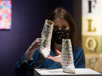 A gallery staff member poses with Damien Hirst X Manolo Blahnik Spot Boots, circa 2002, (est. £2,000-3,000) during a photo call for Bonhams'...