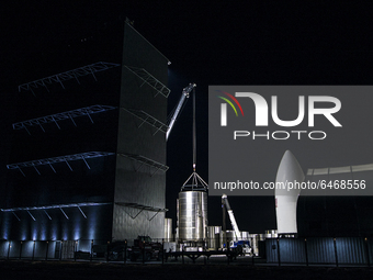 Engineers work into the night dismantling SN-5 and building Super Heavy Booster behind the low bay at SpaceX's south Texas campus on the eve...