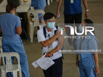 A healthcare worker greets a fellow hospital worker after getting inoculated with the Sinovac COVID19 vaccine during a ceremonial vaccinatio...