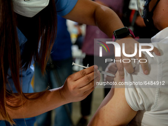A nurse administers the Sinovac COVID19 vaccine during a ceremonial vaccination program held inside a sports stadium in Marikina City, east...