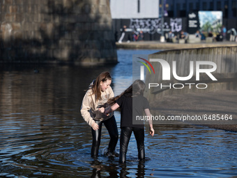   Girls soak up the sun and paddle in the water at New Islington Marina in Manchester city centre on Tuesday 2nd March 2021.  (