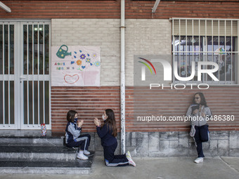 Two girls perform hand games under the gaze of another classmate while having a snack during recess at the Nuestra Señora de Covadonga schoo...