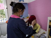 Auxiliary wears child, with alternate clothes, on the day of the daycare center opening on March 15, 2021 in Porto, Portugal. On March 11, t...