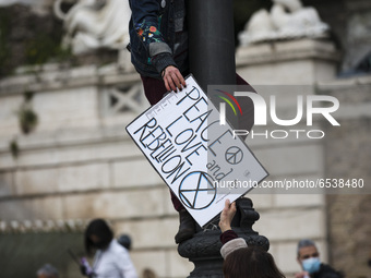 An activist holds a sign as she takes part in a Fridays For Future  demonstration in Piazza del Popolo in Rome,  on March 19, 2021. Dozens o...