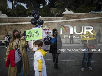A group of people hold signs  as they take part in a Fridays For Future  demonstration in Piazza del Popolo in Rome,  on March 19, 2021. Doz...