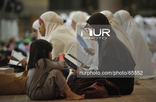 A muslim women reciting Quranic verses for victims of the missing Malaysia Airlines flight MH370 at the National Mosque in Kuala Lumpur on M...