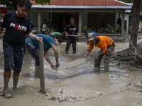Residents and volunteers cleaned up the remaining mud that hit houses in Beka Village, Marawola District, Sigi Regency, Central Sulawesi Pro...