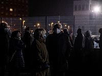 In the picture People queuing in the night outside the Padua exhibition center awaiting vaccination. They all wear protective masks but cann...